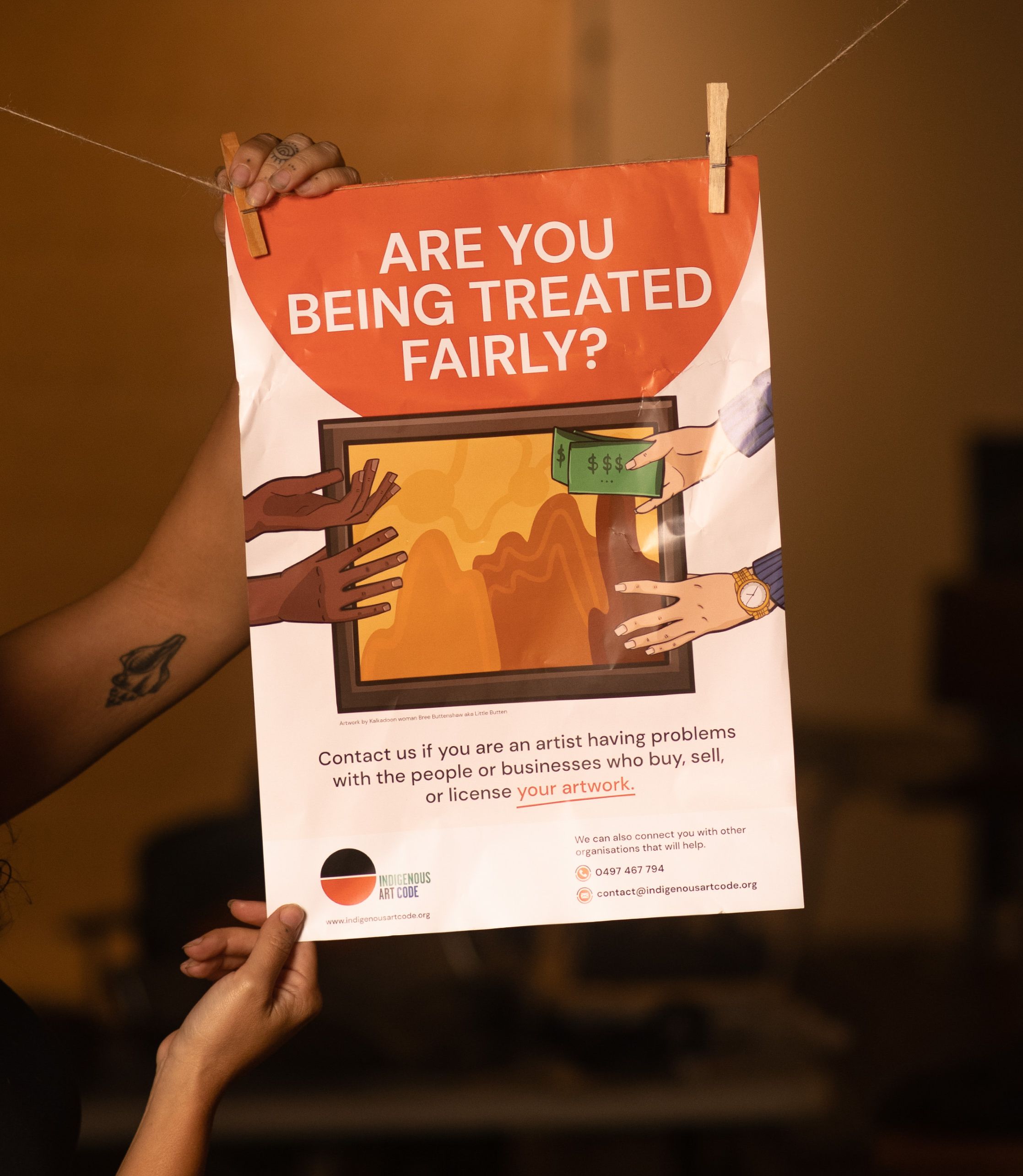 Savannah Travia-Dann with the Indigenous Art Code 'Are you Getting a Fair Go?' poster. Photo by Cole Baxter